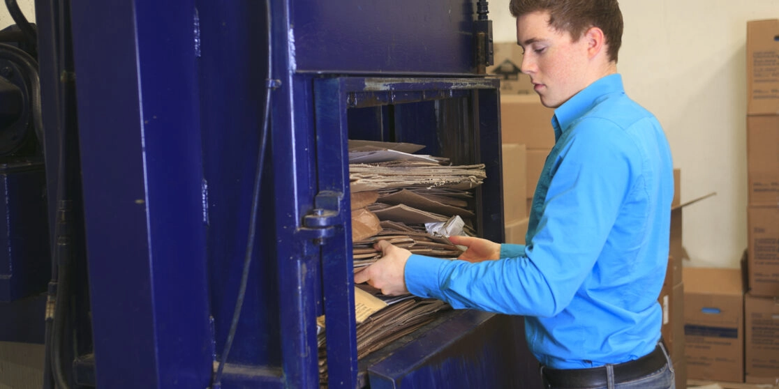 Employee using a cardboard compactor