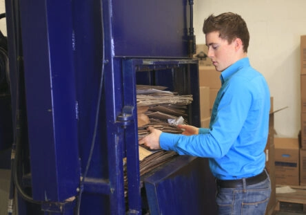 Employee using a cardboard compactor