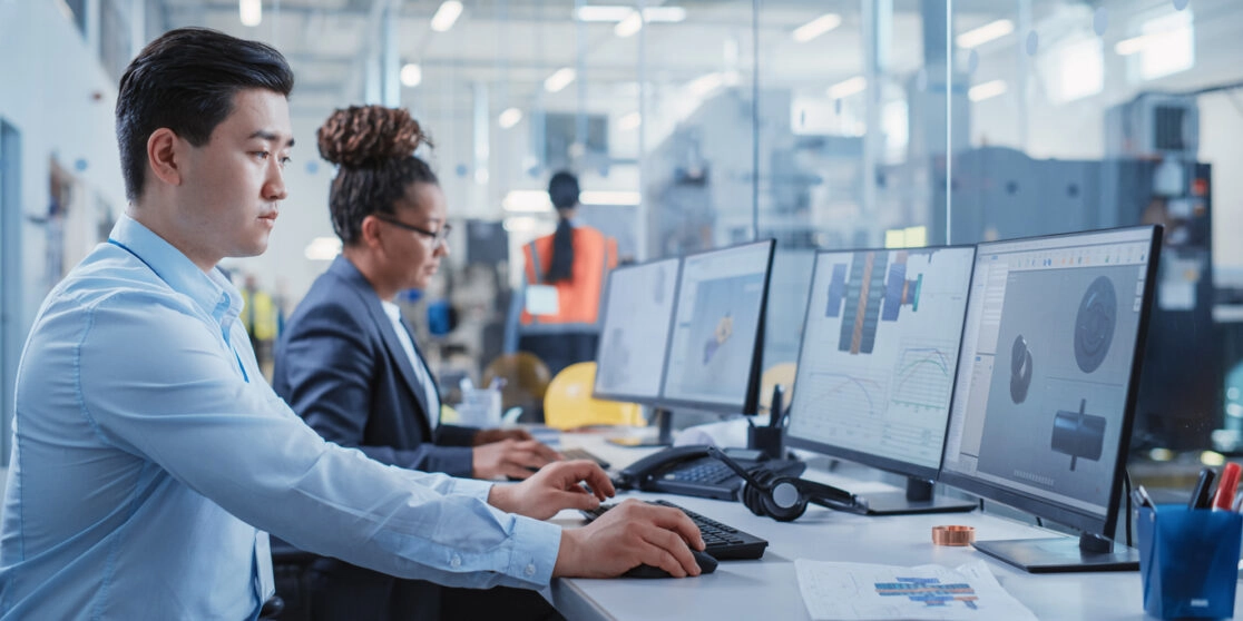 Factory Office Room: Industrial Engineers Developing Models of a Heavy Industry Machine Parts on a Computer 3D Software. Modern Technological Industry 4.0 Research and Development Center.