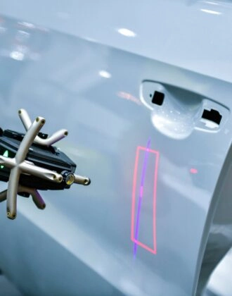 3D scanner on a robotic arm measures the precision of automotive components.
