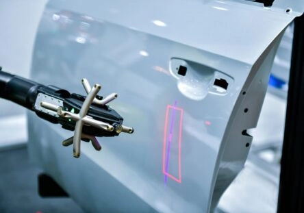 3D scanner on a robotic arm measures the precision of automotive components.
