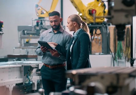 A men and a women are checking a document in a manufacturing facility